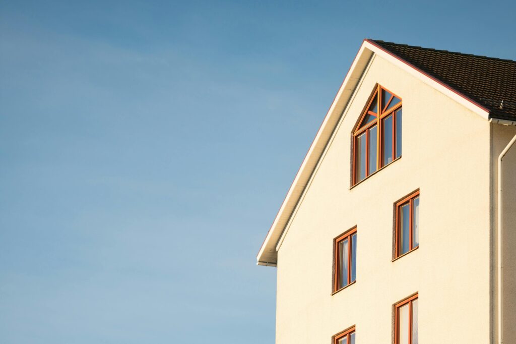 Minimalist modern residential building facade against clear blue sky.